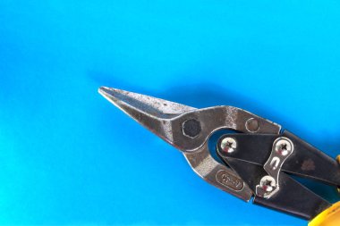 Metal için eski makas. Mavi arka planda metal levha kesme aracı. Boşluğu kopyala.