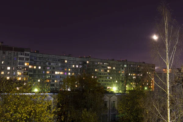 Windows, roofs and facade of a massive apartment building in central Russia at full moon at night. — Stock Photo, Image