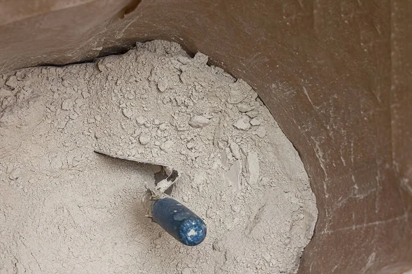 一个装有干砂浆和用于建筑工程的铲斗的打开的纸袋. — 图库照片