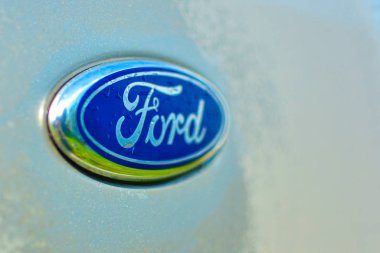 Emblem of the Ford automotive company on the Focus. Russia - October 5, 2019 Emblem with raindrops, selective focus, copy space.
