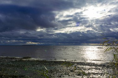 Yağmurdan önce nehrin üzerinde alçak ve kara bulutlar. Arkaplan için dramatik manzara.