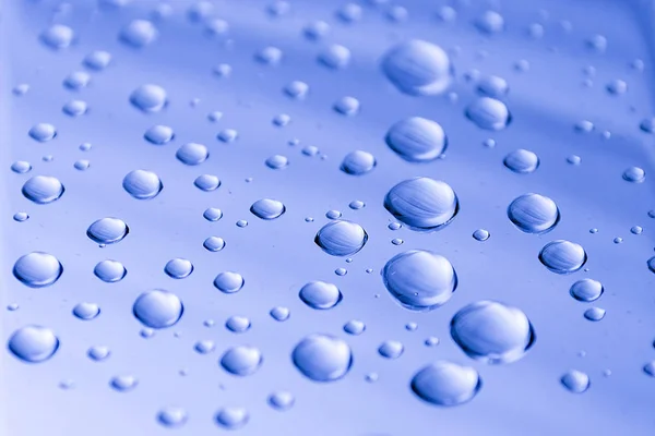 Капли воды на голубую металлическую поверхность. Абстрактный синий фон из капель воды. Селективный фокус . — стоковое фото