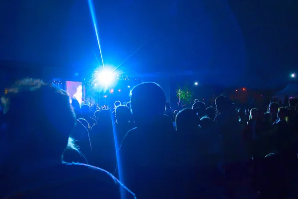Sahne ışıkları altında çok sayıda insanın siluetleri var. Kavram: Kutlama, ralli, konser, toplu kutlamalar, protestolar. — Stok fotoğraf