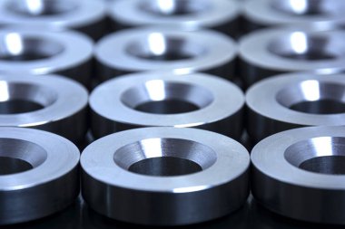 Tasarım ve tasarım için soyut teknoloji geçmişi. Torna tezgahına monte edilmiş metal parçalar koyu bir arka planda serilmiştir. İşlenmiş endüstriyel parçalar.