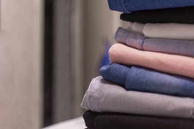 Moda kıyafetleri. Bir sürü renkli kot pantolon. Bulanık bir arkaplanda. yumuşak odak.