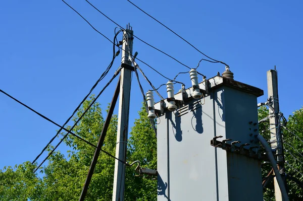 Pilone elettrico con trasformatore e fili contro un cielo blu. Il concetto di elettricità . — Foto Stock