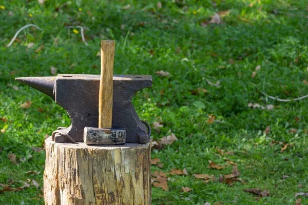 En el muñón de las herramientas de un herrero: martillo y yunque. El concepto de trabajo manual, artesanía. Copiar espacio — Foto de Stock