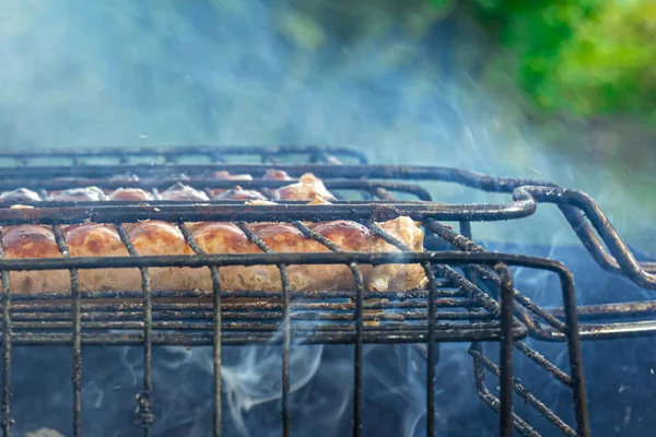 Grillowane kiełbaski na grillu. Kiełbaski z grilla. Gotowanie na świeżym powietrzu. Koncepcja: rekreacja na świeżym powietrzu, pyszne, naturalne jedzenie, relaks i rozrywka. — Zdjęcie stockowe