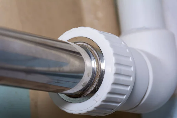 Metal bir borunun PVC borusuna bağlanması. Yakın plan. Konsept: Su ve tesisat, boru bakımı ve onarımı.