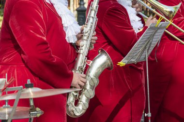 Kırmızı elbiseli bir saksafoncu. Konsept: Saksafon çalmak, müzik. Saksafon caz müzik enstrümanı Alto saksafoncu eller Kapalı Saksafoncu.