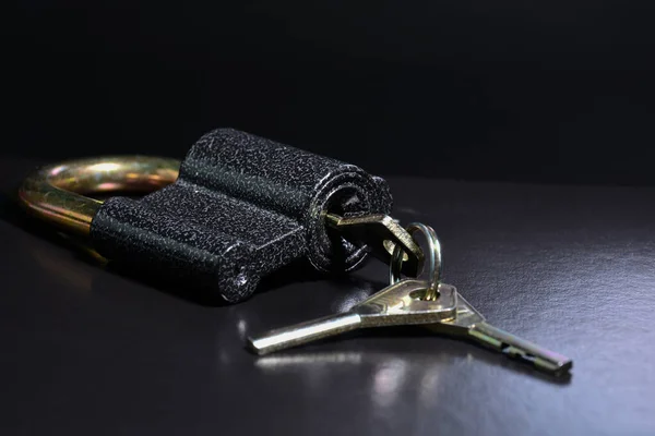 Κλειδαριά με κλειδιά σε μαύρο φόντο. Κλείδωμα μεταλλικού λουκέτου. — Φωτογραφία Αρχείου