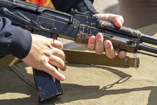 Closeup male hands holding a machine gun, selective focus. At hand. A man holds a submachine gun. The concept of war, exercises. Firearms in male hands. — Stock Photo, Image