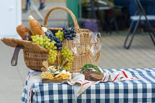 Fruit basket and wine. On a picnic. Grapes and wine in a basket