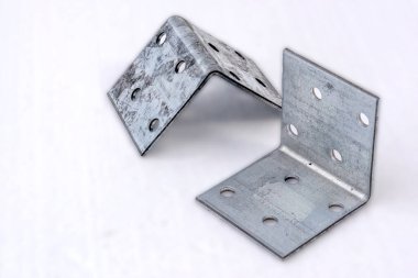 Delikli metal köşeler. Beyaz arkaplanda aksesuarlar bağlanıyor.