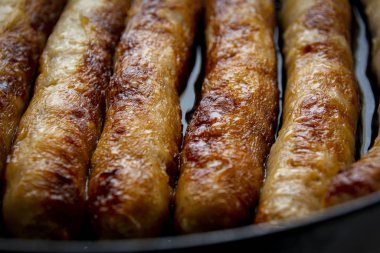 Portatif ızgarada leziz sosisler, ateşte kızartılmış. Yaz pikniği, ızgara sosis. Proje ve tasarım için gıda arka planı.