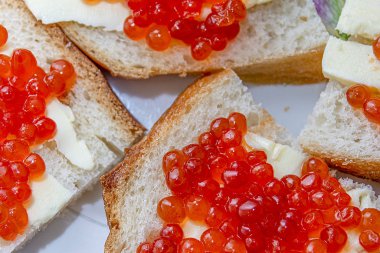 Ekmek ve tereyağından yapılmış sandviçler ve kırmızı havyar. Kırmızı havyarlı ekmek ve tereyağı. Gurme yemeği. Yakın plan..