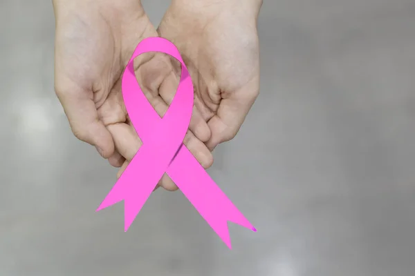 Розовая лента в руках. Концепция рака — стоковое фото