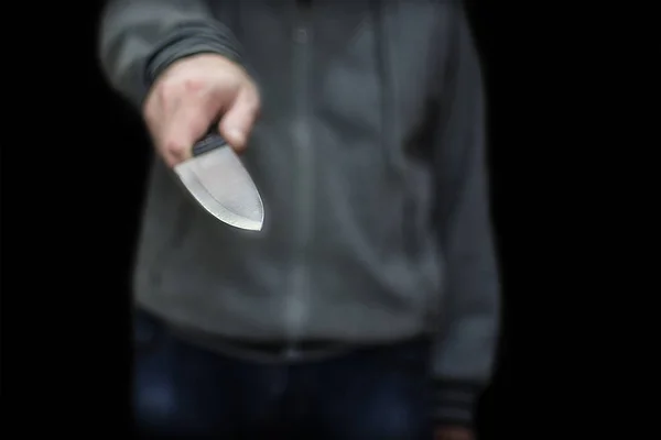 Un hombre ataca con un cuchillo. La amenaza de las armas frías. El concepto de crimen y robo . — Foto de Stock