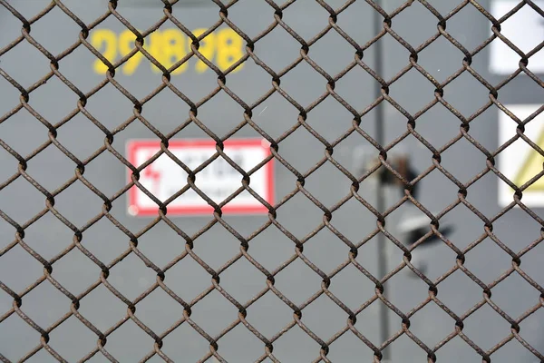 The danger of high voltage. steel mesh fence high-voltage transformer substation outside. Soft focus. Abstract background for design. — Stock Photo, Image