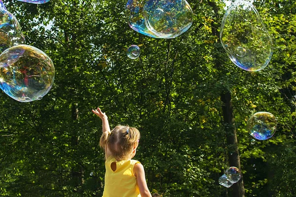 Child catches soap bubbles. soft focus. — Stock Photo, Image