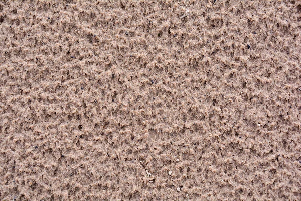Vlhký říční písek. Nerovné pozadí mokrého říčního písku. — Stock fotografie