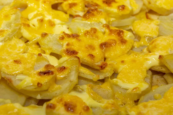 Krumpli Rosti, sajttal, közelről. A burgonya és a sajt elvont háttere. Növényi növekedés, burgonyapalacsinta sült burgonyával és sajttal. — Stock Fotó