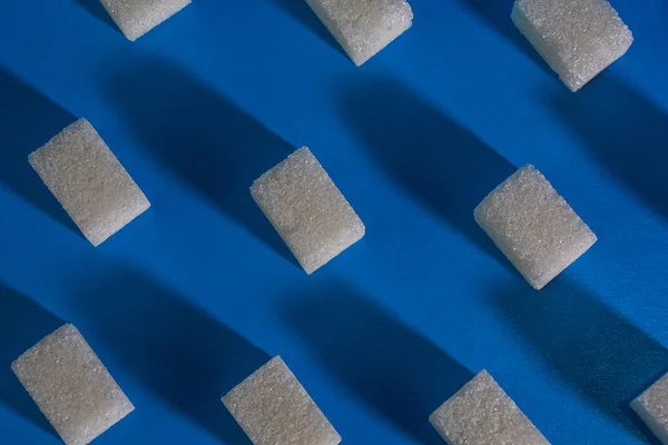 Кубики сахара на синем фоне. Абстрактный фон. — стоковое фото