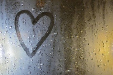The image of the heart on the misted window. Concept: sad mood, sadness and boredom for a loved one.