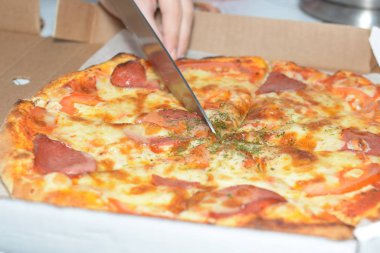 Pizza in a carton box. Pizza delivery. Pizza menu. Knife cuts pizza