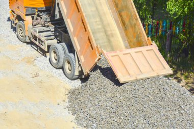 The process of unloading a dump truck, dump truck unloads rubble on the ground, top view. The concept of road construction, construction, shipping, road repairs.