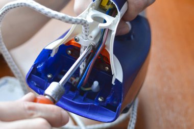 Tornavidayla bir el demiri söker. Konsept: ev aletleri onarım, bakım ve önleme.