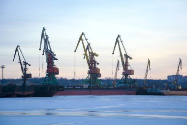 Kış günü bir nehir limanında vinçler. Kış portu.