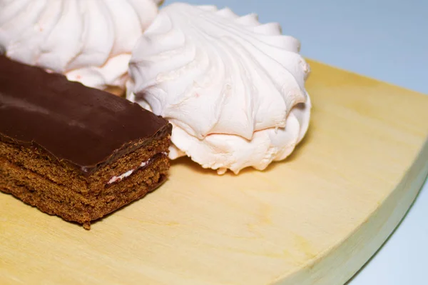 Dolci biscotti primo piano su una tavola di legno. Meringa, torta shokoladniy. Il concetto di tè tratta, dolci per bambini, delicatezza, dieta, peso eccessivo, carie . — Foto Stock