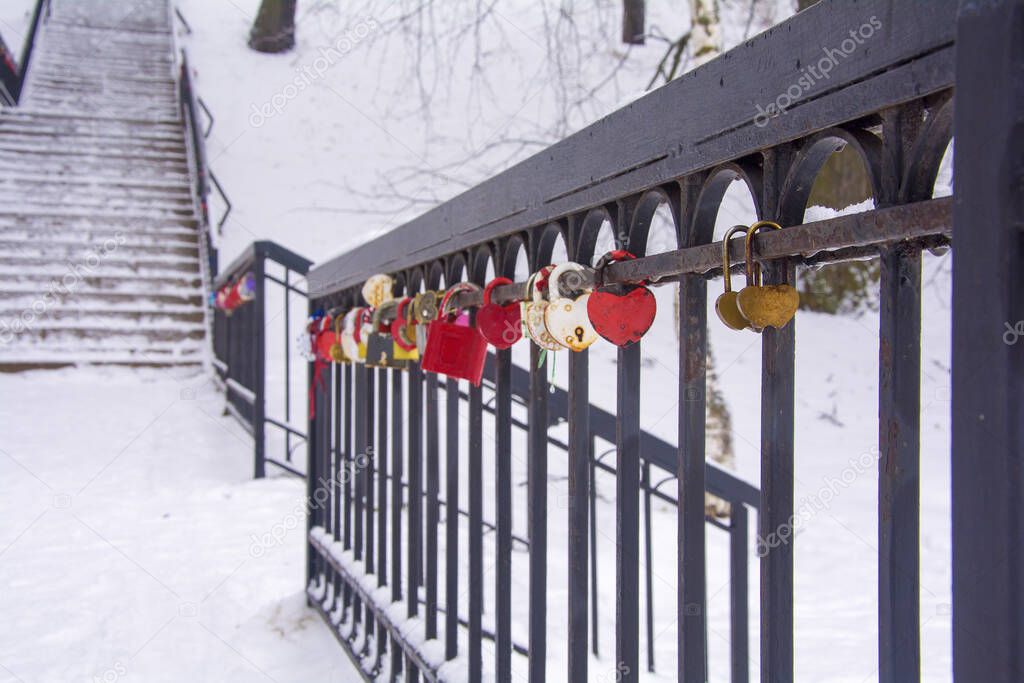 wedding locks on the railing of the stairs. Locks in the shape of a heart - a symbol of love. close-up. soft focus.