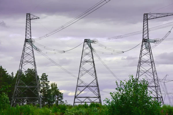 High-voltage line against a cloudy sky. h-voltage pole against the cloudy, cloudy sky. Power transmission line pole against dark blue cloudy sky. Support pole for high voltage. Rainy day.