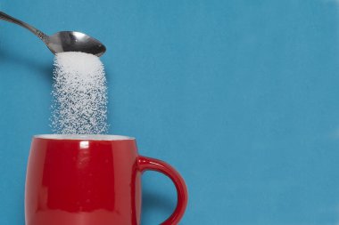 Çay kaşığı şekeri fincana koyar. Aşırı şeker tüketiminin tehlikeleri kavramı. Diyabet mellitus, caries.