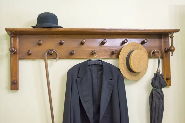 Old coat rack with umbrella, hat and coat. The concept of the interior of the last century.