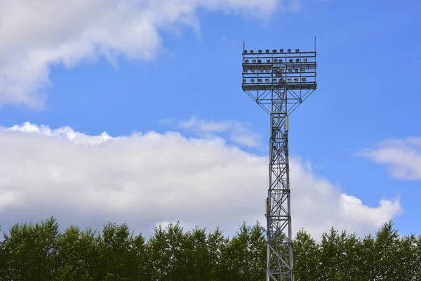 Supporto illuminazione. Illuminazione stadio Post. Pilastro alto con faretti per illuminare uno stadio di calcio contro il cielo con nuvole — Foto Stock