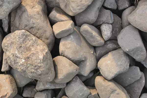 Bruine stenen achtergrond. Natuurstenen voor de achtergrond. Veel stenen liggen op de grond. Abstracte achtergrond. — Stockfoto