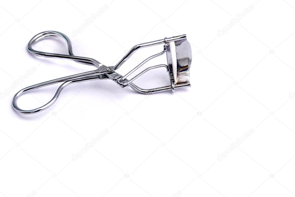 Tool for curling eyelashes on a white background. Close-up. Copy