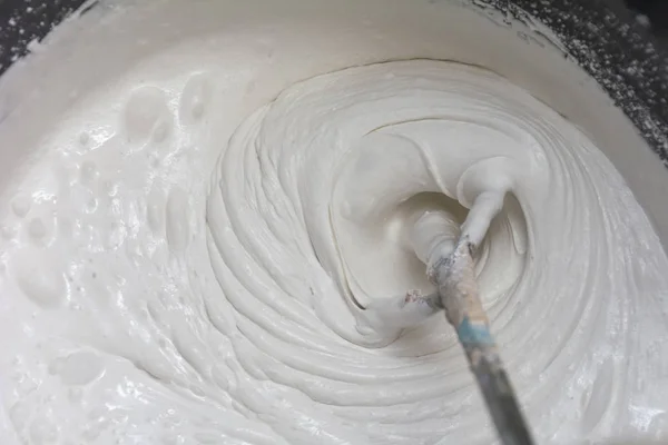 Building mixture in the process of preparation. A worker mixes t