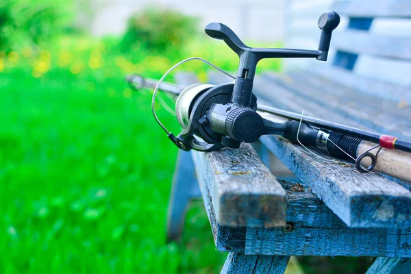 Fishing rods and fishing tackle on a wooden bench. Concept: outdoor activities, fishing, hobbies. Copy space. — Stock Photo, Image