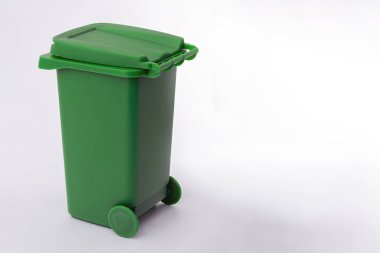 Beyaz arka planda yeşil bir çöp bidonu. Boşluğu kopyala.