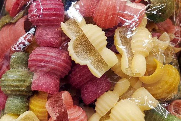 Colorful pasta is packed in cellophane packaging. Abstract pasta