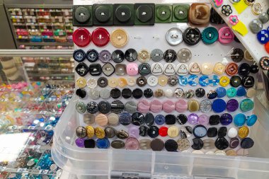 Bir mağazada satılık çok renkli düğmeler. Dükkandaki düğmeler. Dikiş ve dikiş atölyesinde çok çeşitlilik var. Soyut renkli arkaplan.
