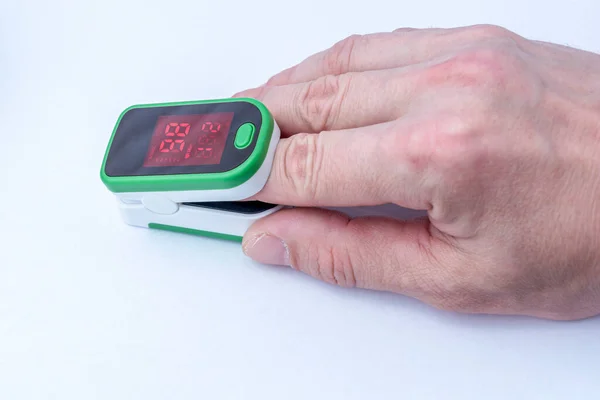 血中酸素飽和度を測定するためにパルス酸素を身に着けている手のクローズアップ 診断コンセプト Covid — ストック写真