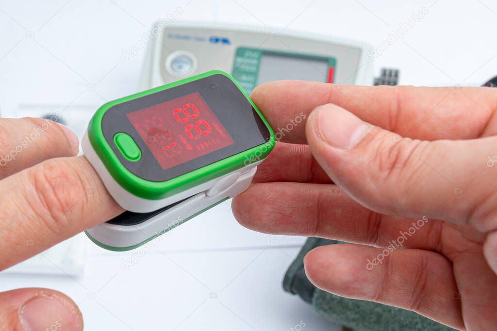 Pulse Oximeter, finger digital device to measure person`s oxygen saturation. Close-up. Reduced oxygenation is an emergency sign of pneumonia. Prevention and diagnosis of mers covid 19