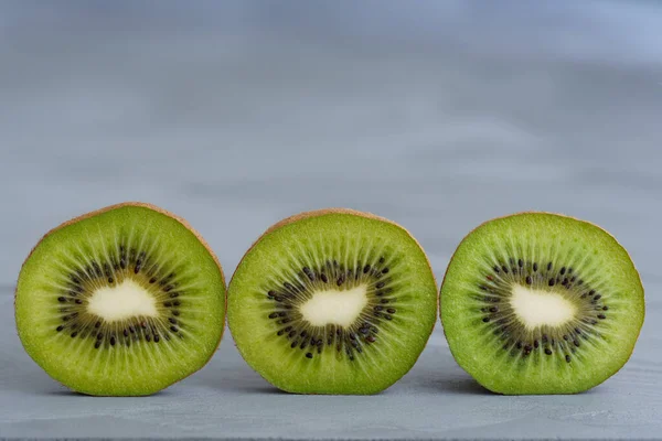 Macro shot of organic kiwi slices. Grey rustic background, high resolution
