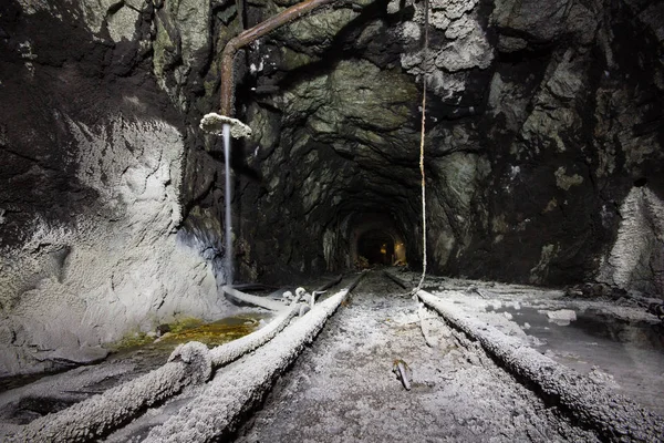 Underground gold mine shaft tunnel drift with white rocks