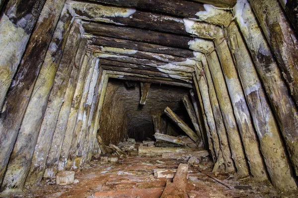 Underground gold mine shaft tunnel drift with wooden timbering